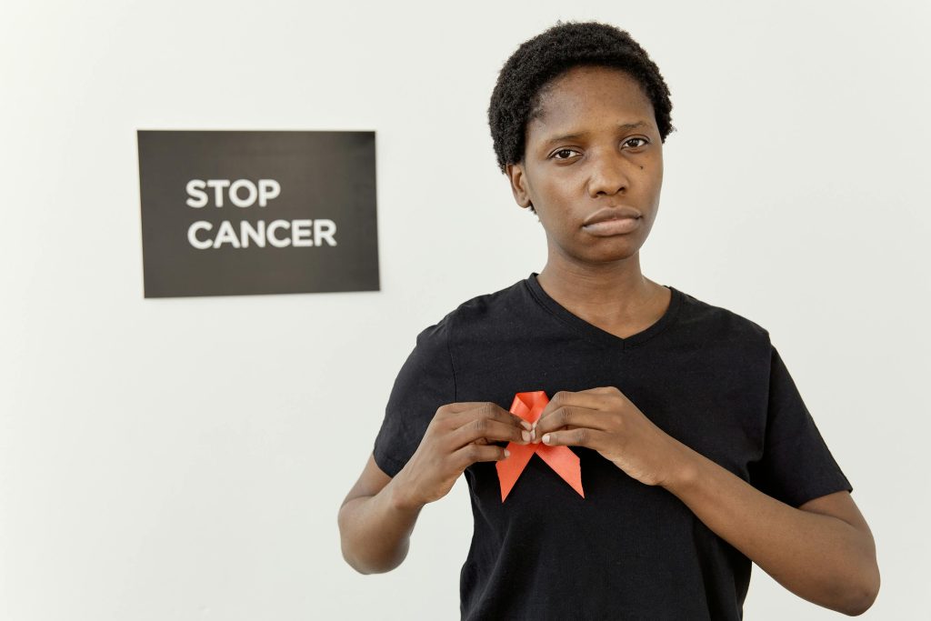 Portrait of woman promoting cancer awareness with red ribbon.